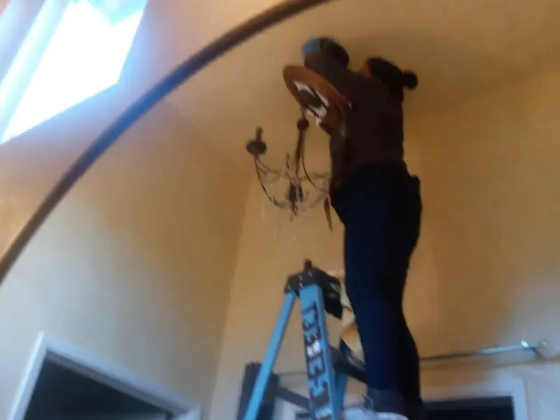 Electrician installing a chandelier in a North Madison residence